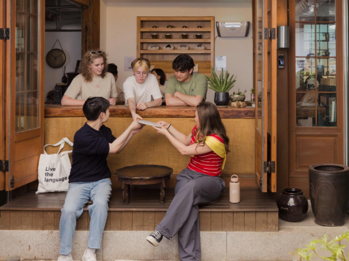 Group of EF Gap Year students sitting together in a traditional tea house in Seoul, South Korea, sharing drinks and enjoying cultural immersion.
