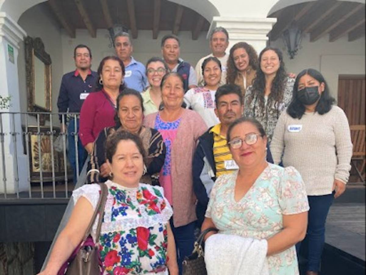 Group of people smiling and standing together in a collaborative setting, representing a team or internship group.
