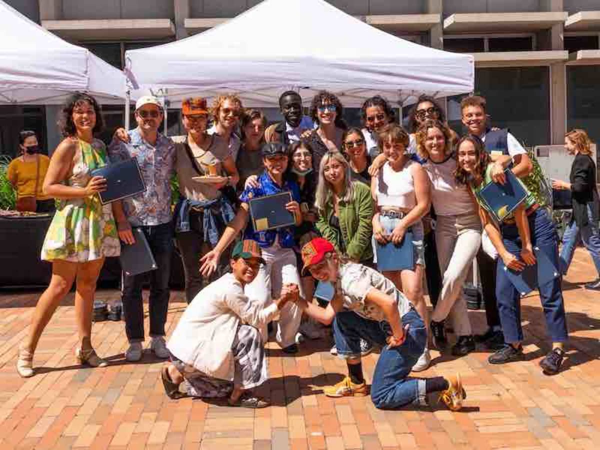 Group of students before a white canopy, posing for group picture