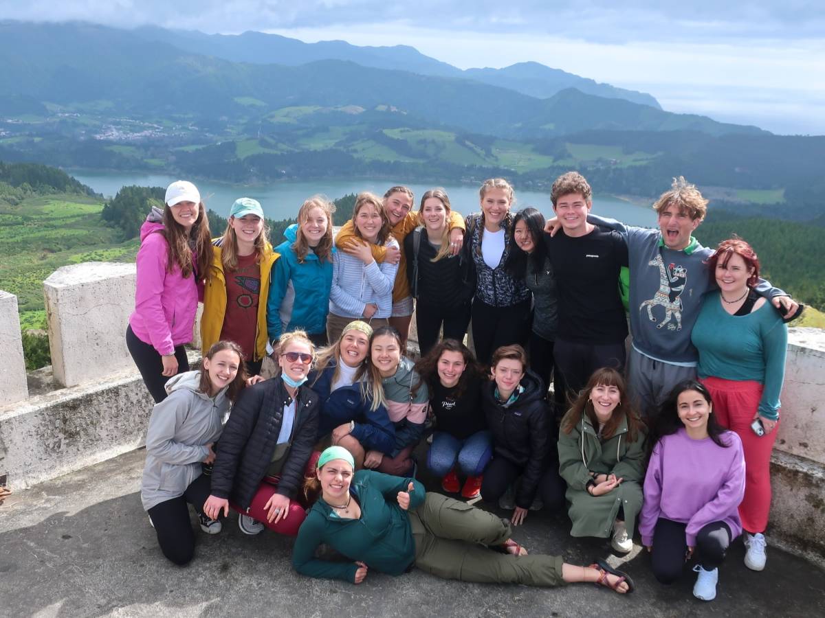 Group of students pose for a photo at top of mountain