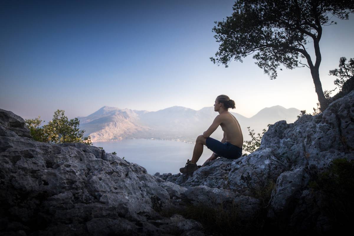 guy sitting on a rocky mountain