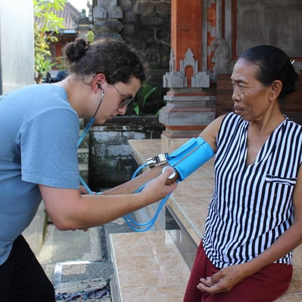 teen takes blood pressure for Balinese woman