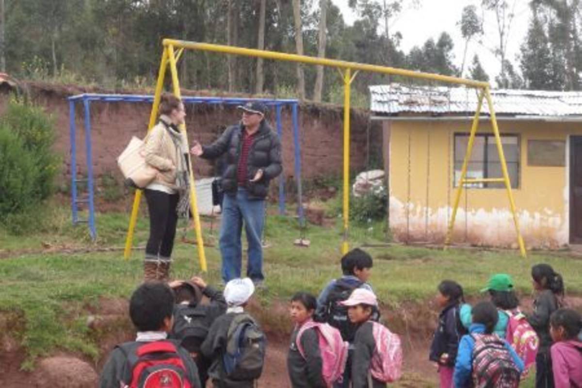 Intern speaking to teacher at the playground with children