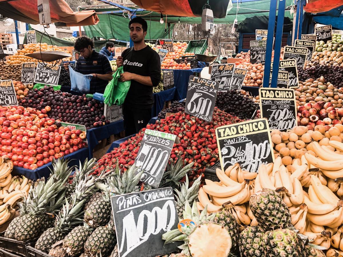 Interns exploring a vibrant outdoor market in Chile, browsing fresh produce, crafts, and local goods.