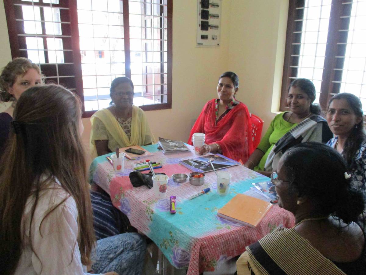 interns gathered around table with Indian women