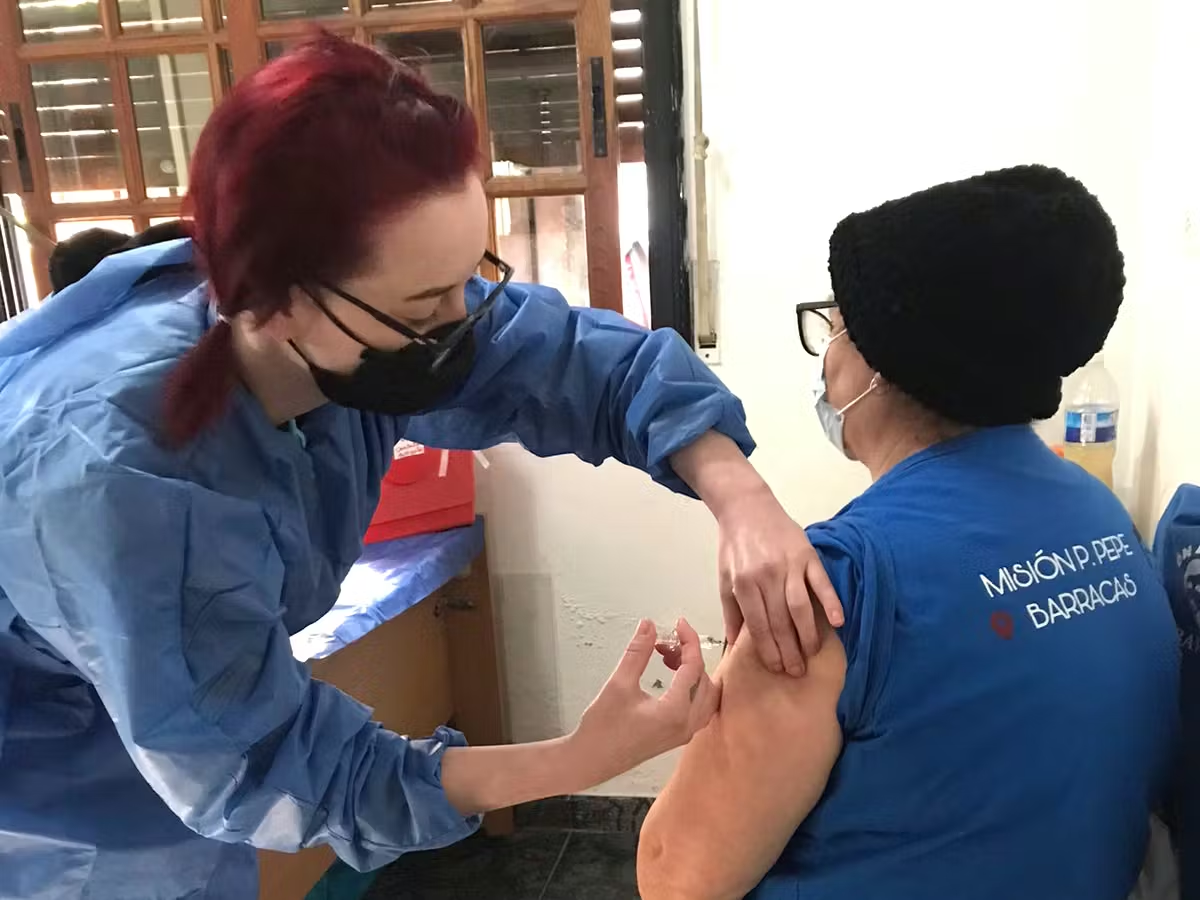 IVHQ Volunteer giving a senior citizen a vaccine 