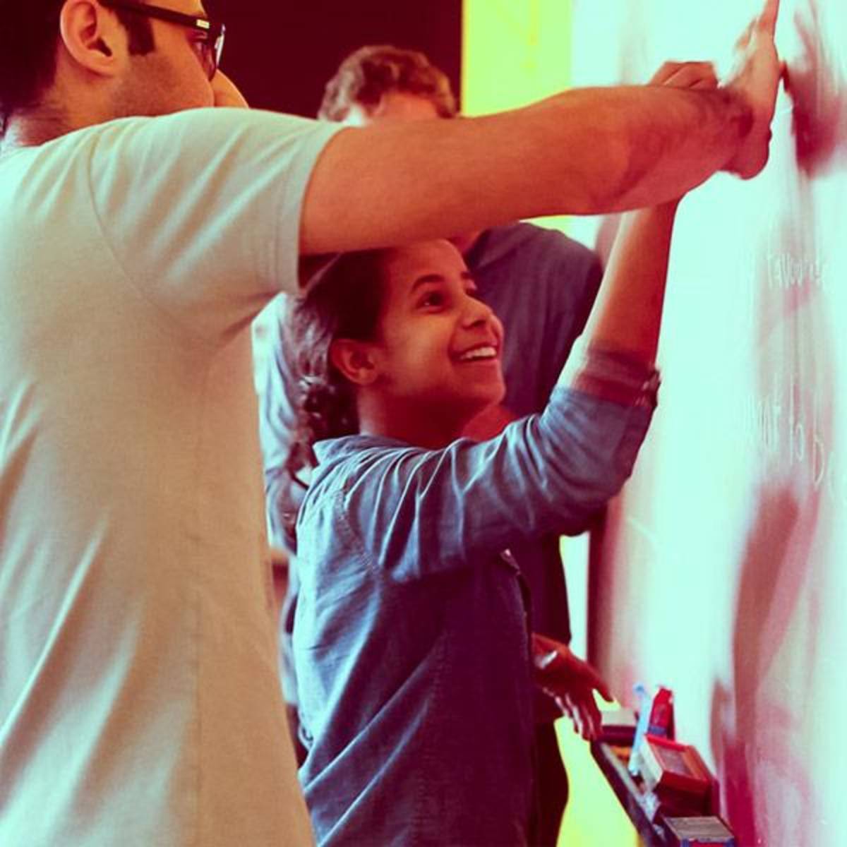 A teacher and a student writing on the board