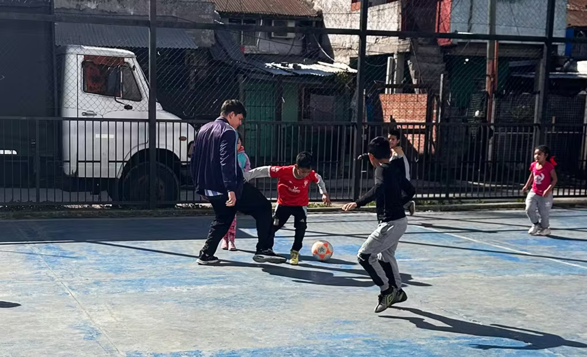 IVHQ Volunteer playing football with a class of younger children