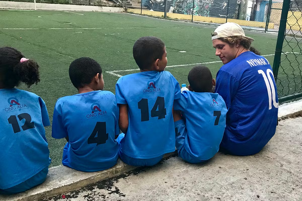 IVHQ Volunteer sitting by a football pitch with his sports students