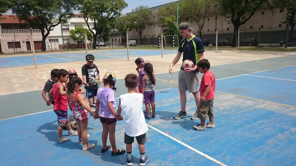 IVHQ Volunteer teaching a class of children kickball