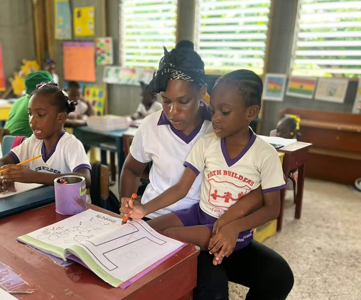 IVHQ Volunteer Teaching a Local Child about the Alphabet