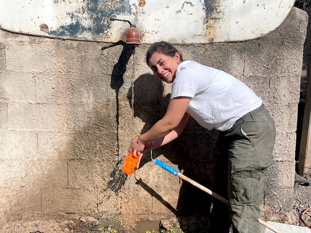 IVHQ Volunteer washing off a paint roller in Argentina