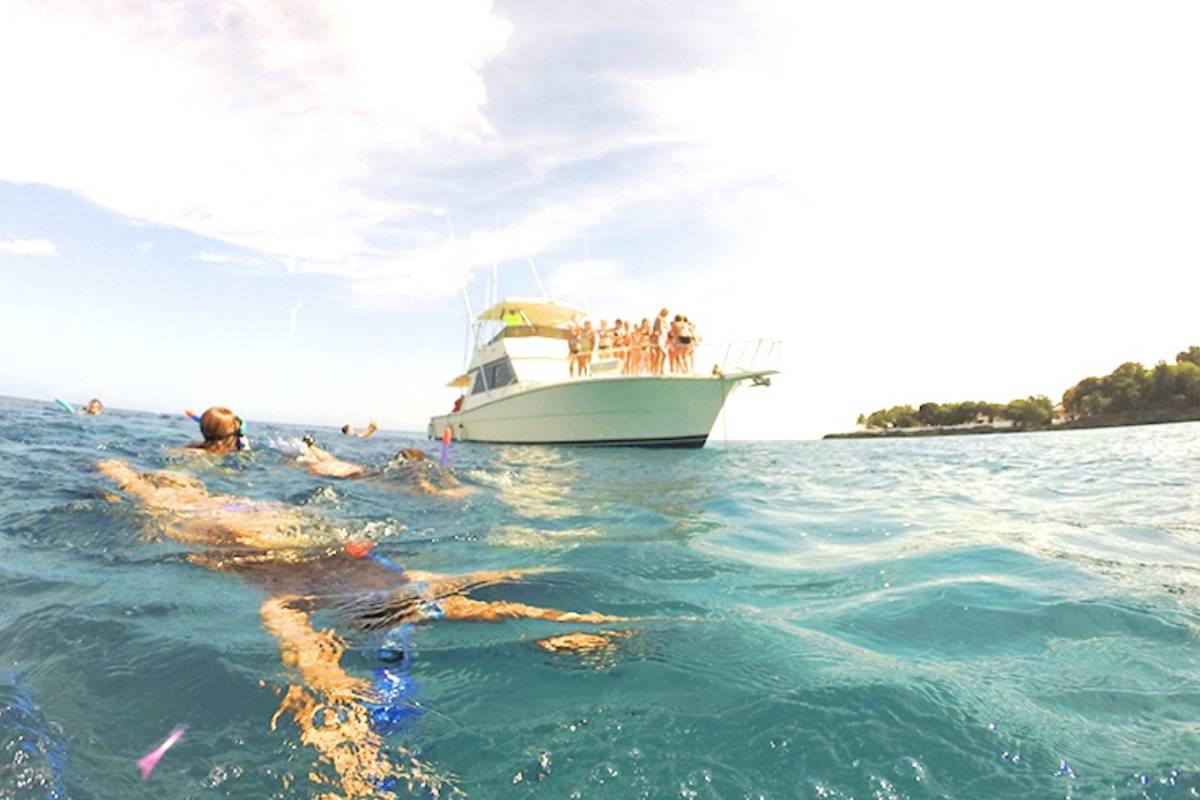 Kids snorkel off a boat