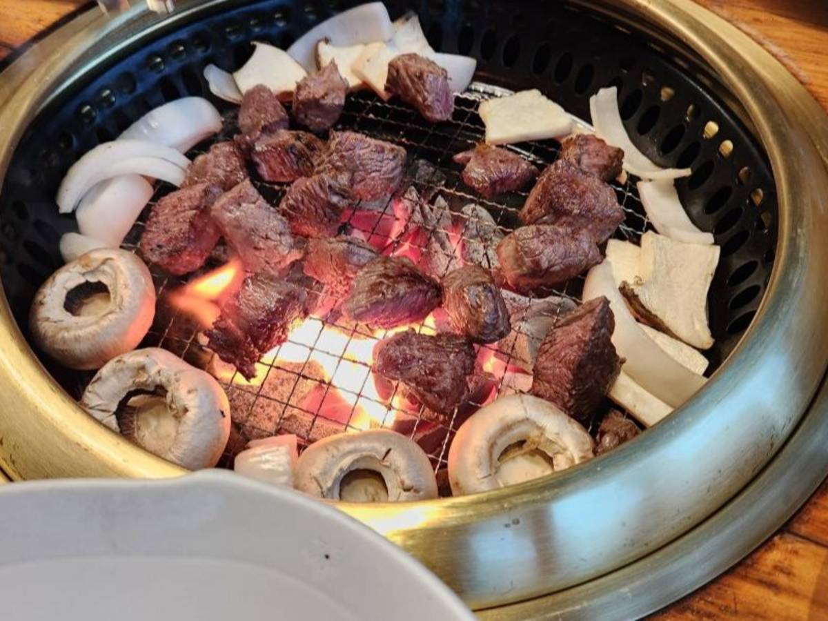 Korean bbq and vegetables being cooked on a grill.