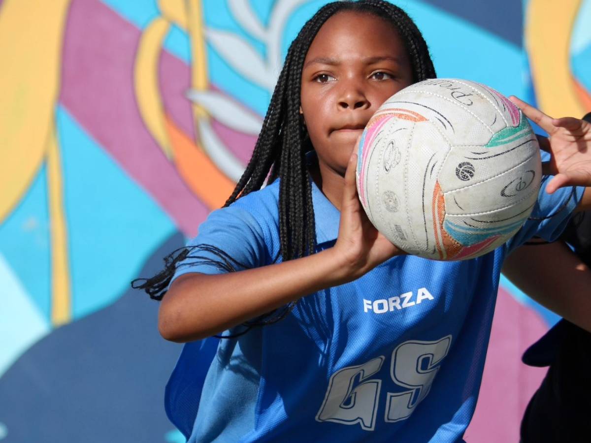 LBS student in netball kit with colourful mural, Lüderitz