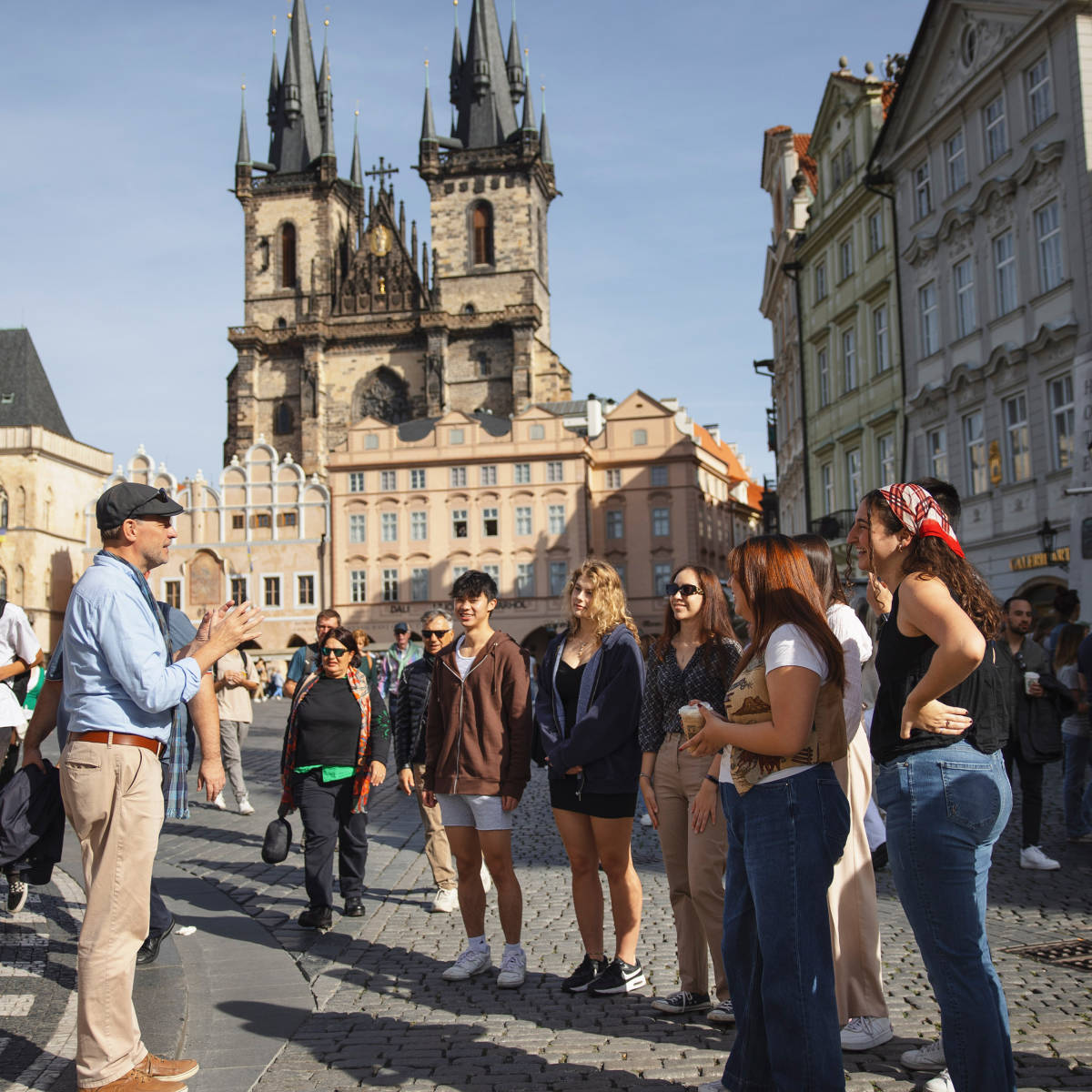 Lecturer and students stand in front of a church. 
