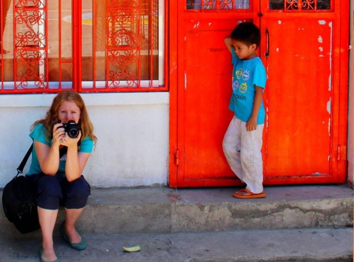 Volunteer holding her camera beside a child.