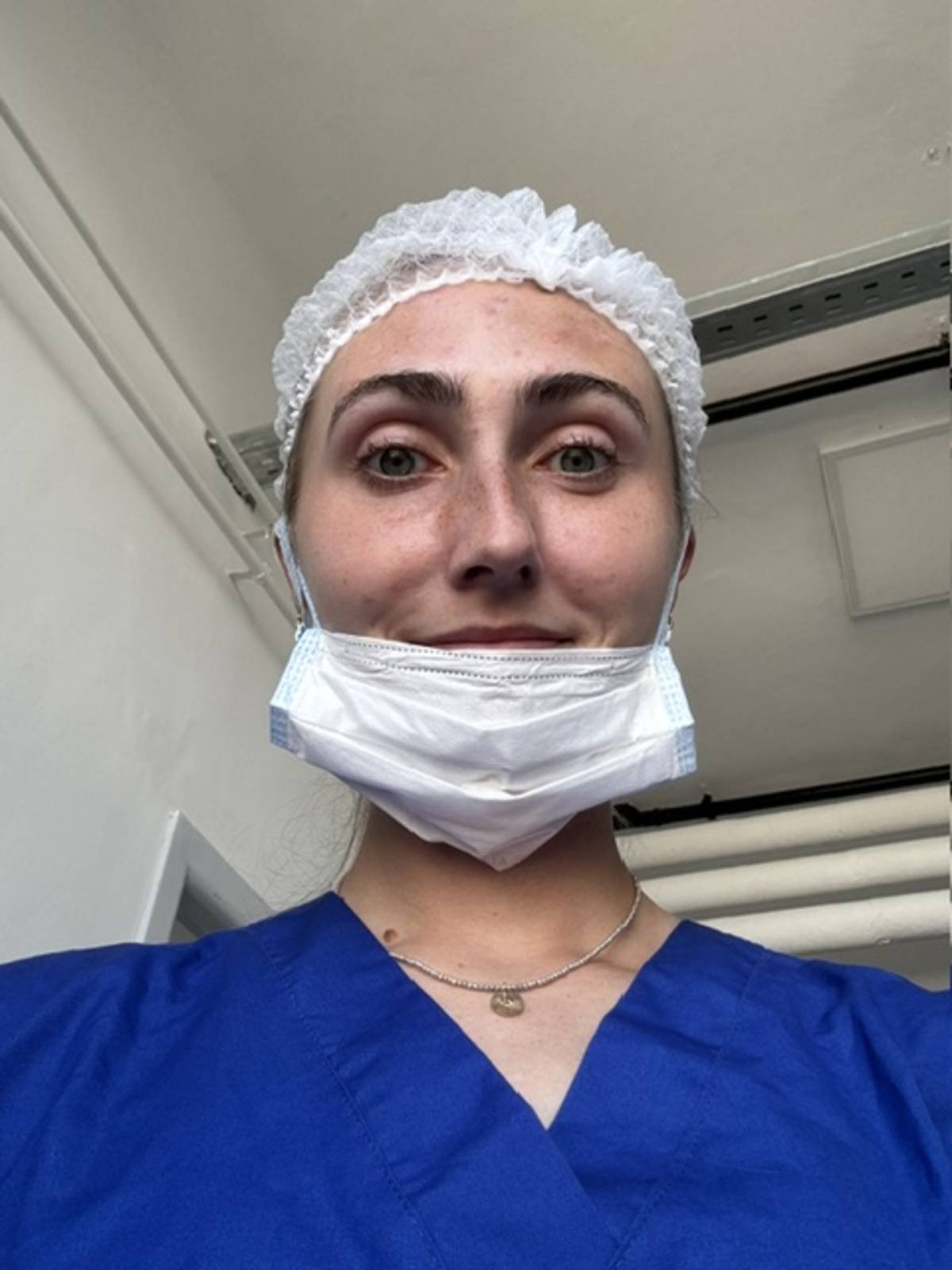 Medical intern in Uruguay taking notes while observing a doctor during patient rounds in a hospital setting