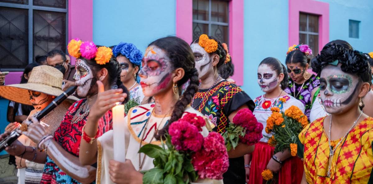 Mexican people in traditional attire with their faces painted like sugar skills