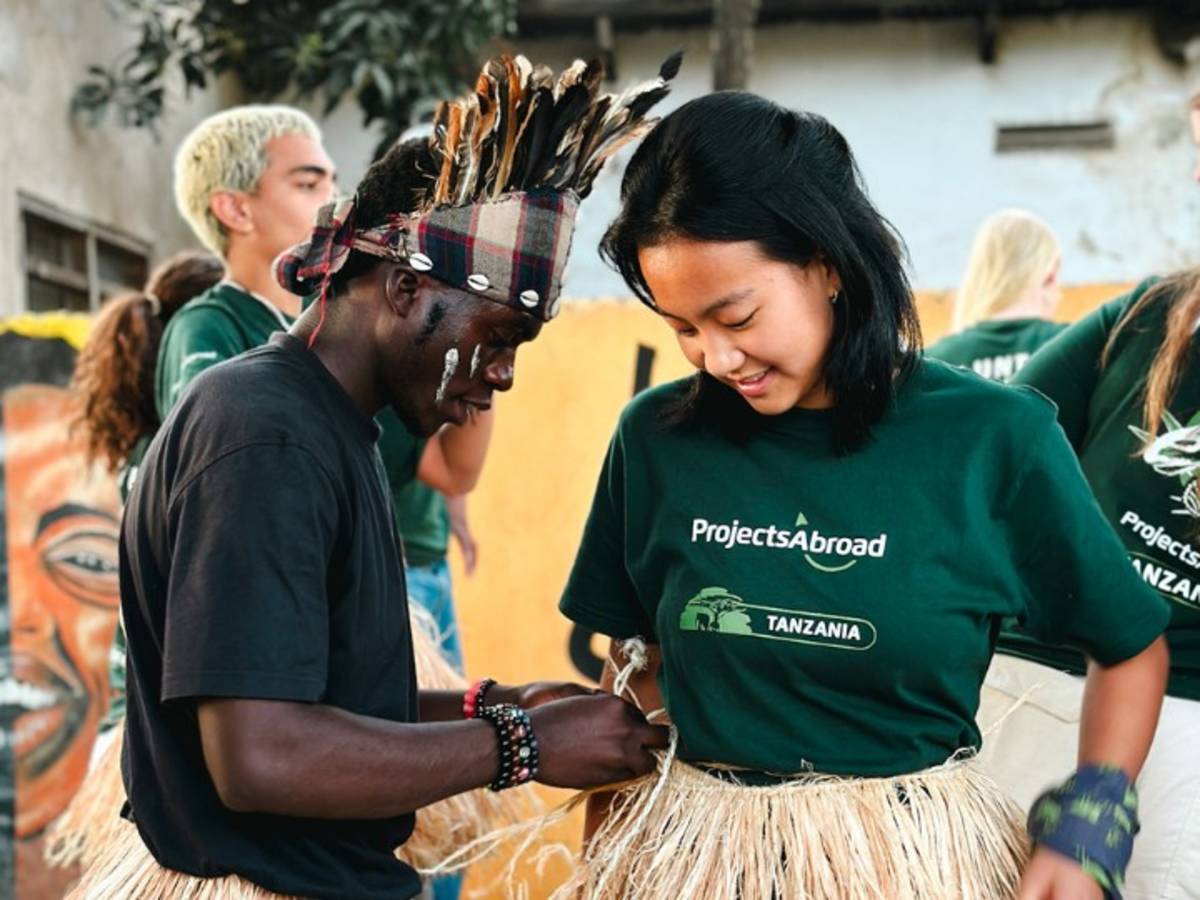 Our local staff help a participant to dress in cultural clothing