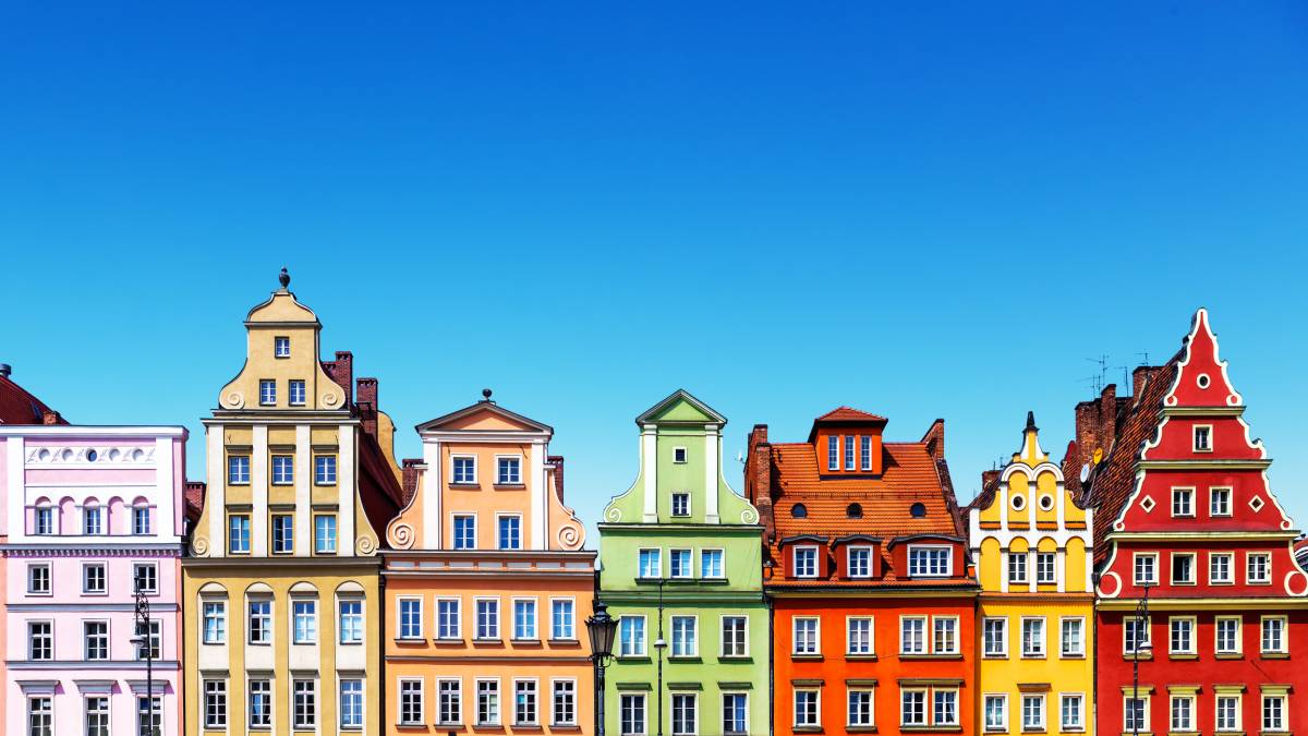 Rows of colorful historic townhouses under a bright blue sky
