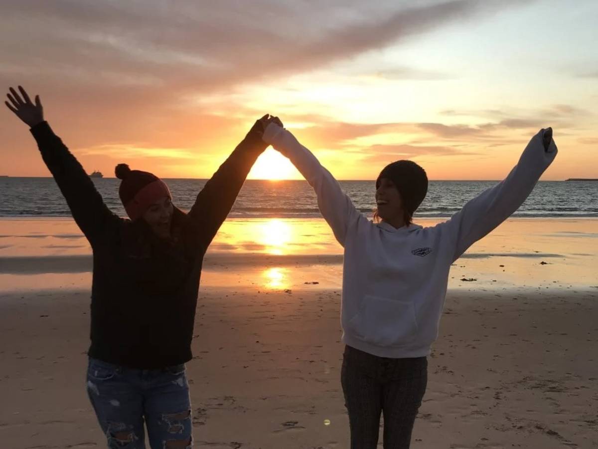 RVF teachers celebrating a sunset on a Spanish beach, full of joy.