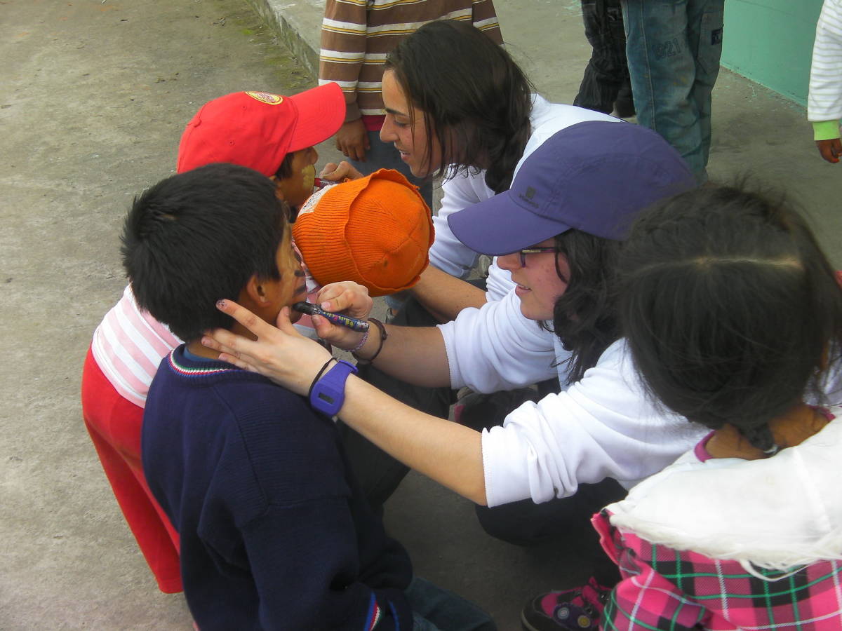 volunteers doing face paint on children