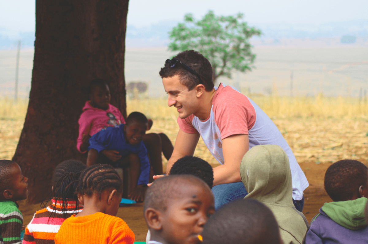 Male volunteer with children outside