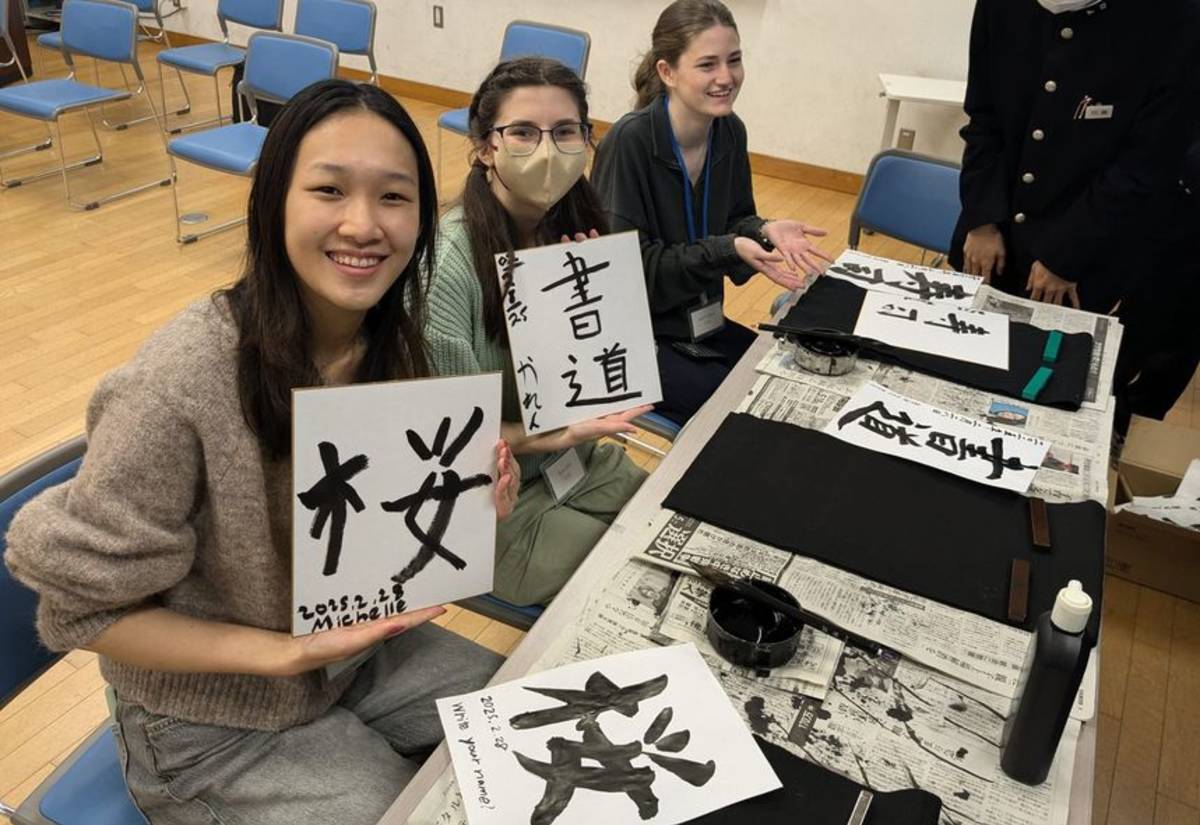 Semester abroad teens holding up their kanji in a classroom