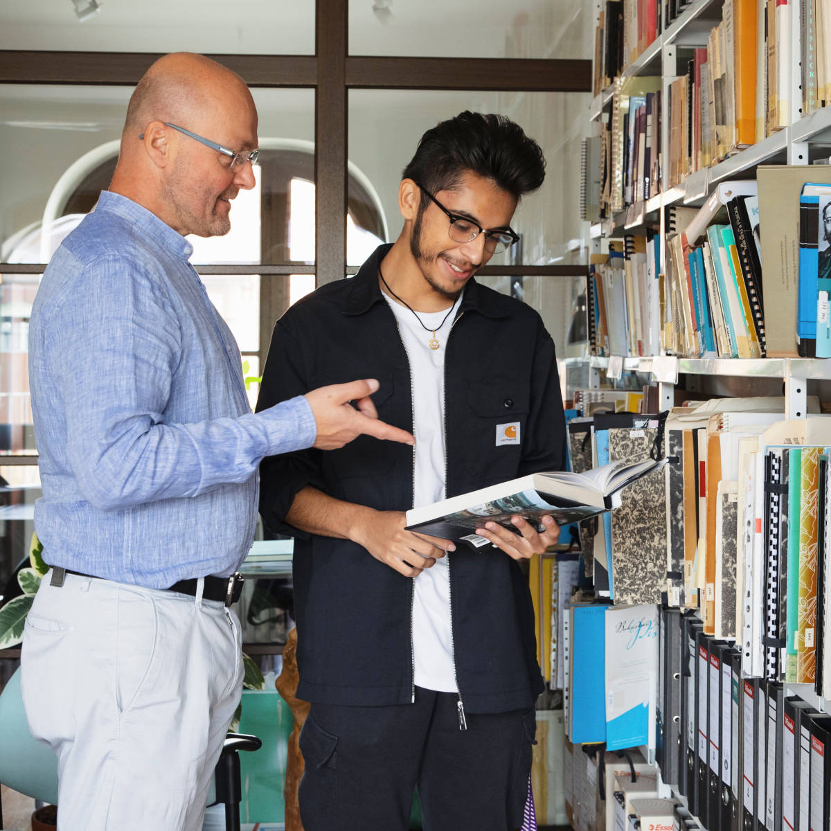 Student and lecturer study in library. 