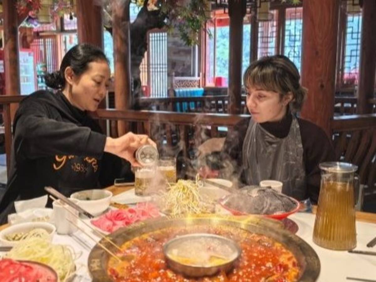 Student eating with her teacher at a Chinese restaurant in Chongqing