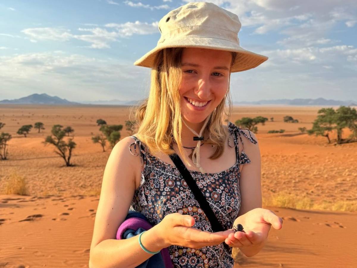 Student holding a desert beetle in the Namib dunes