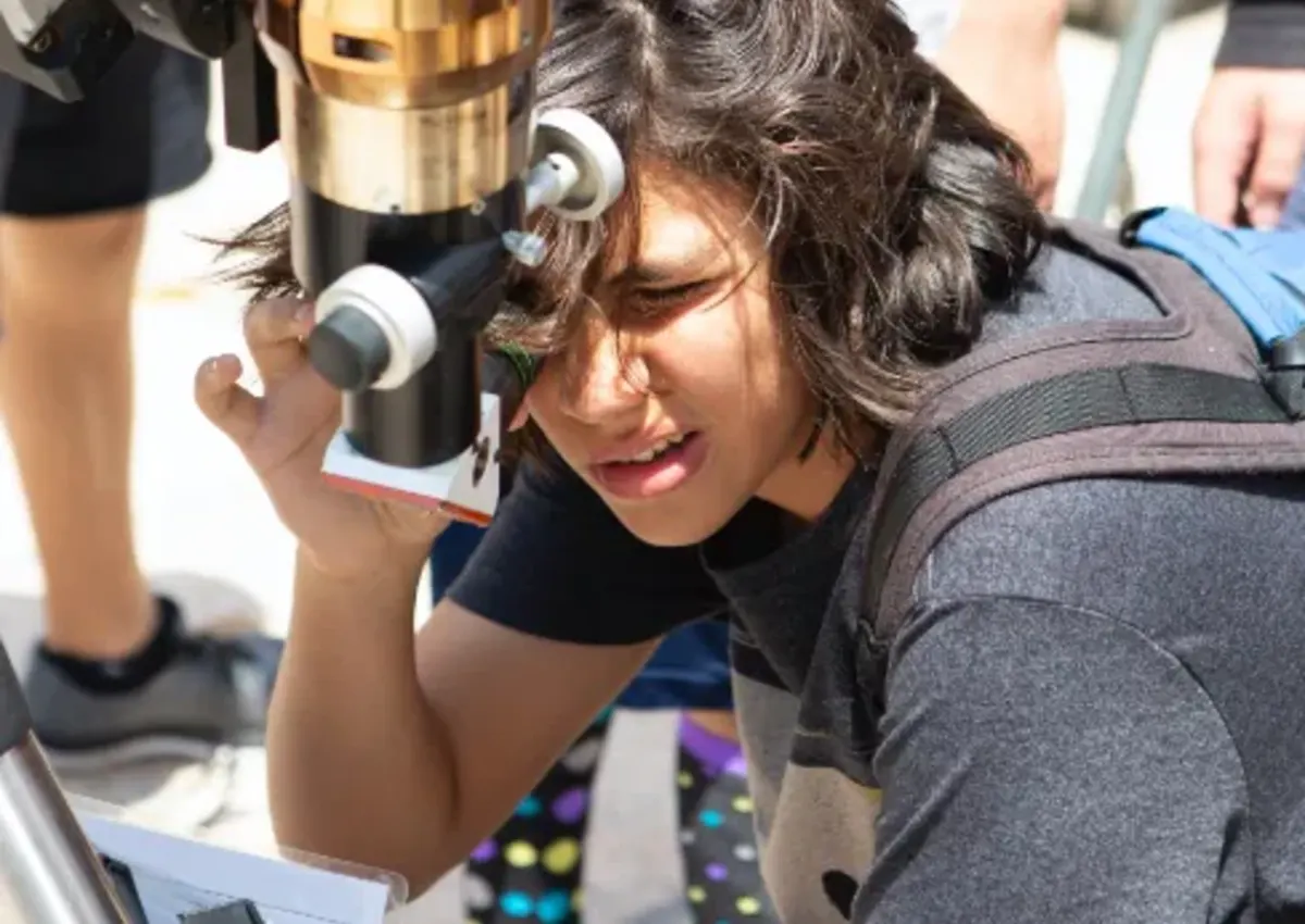Student looks through microscope