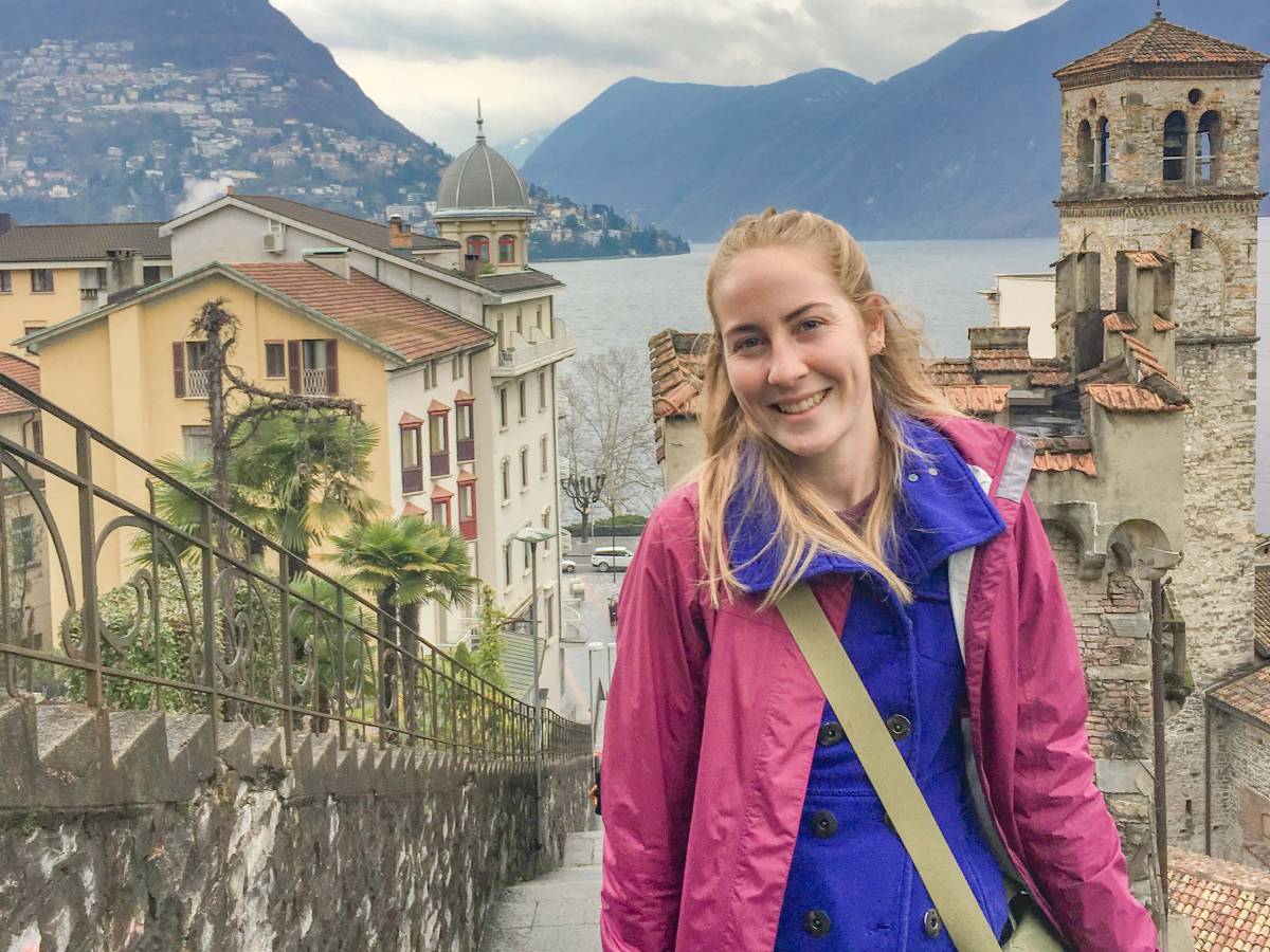 Student posing in front of mountain town in Switzerland