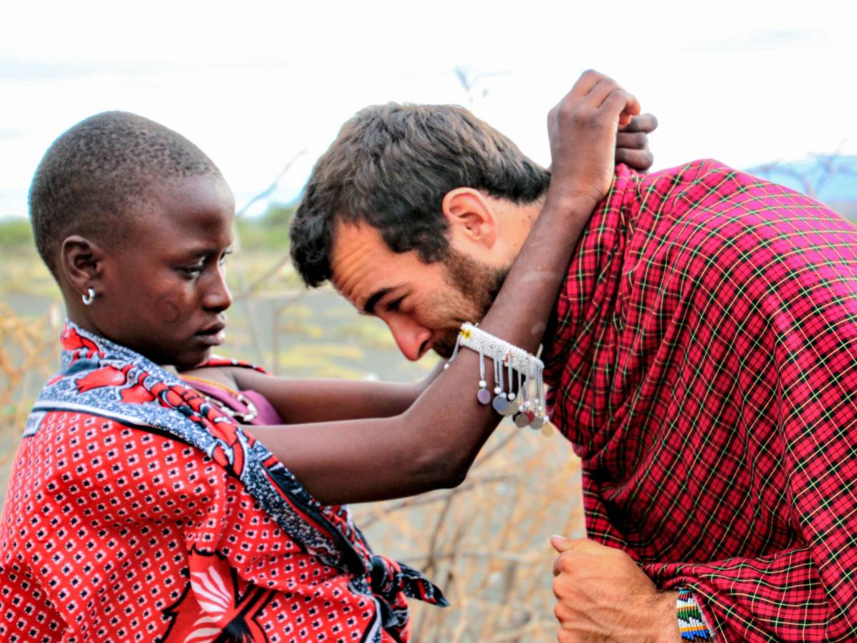 Student receiving a necklace from Maasai woman