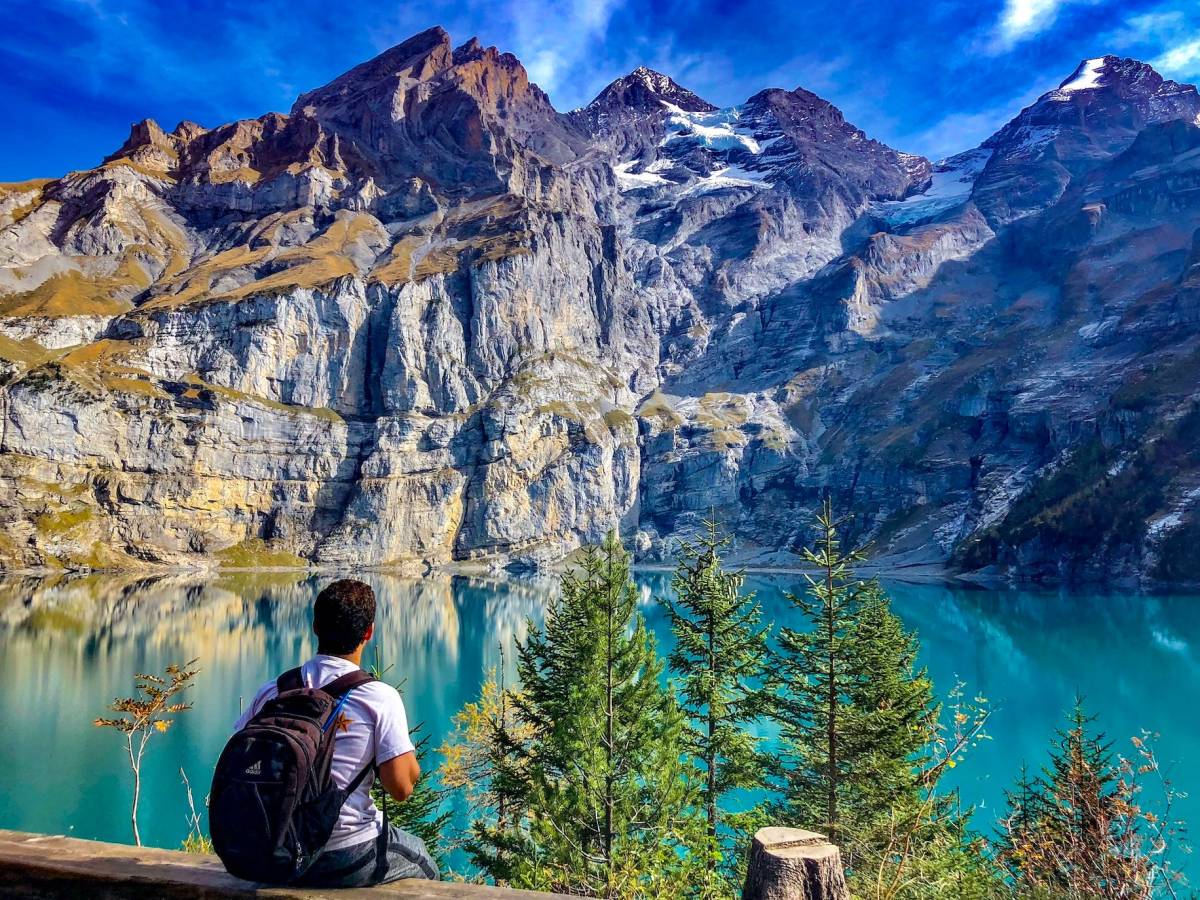 Student sitting in front of lake and mountains in Switzerland