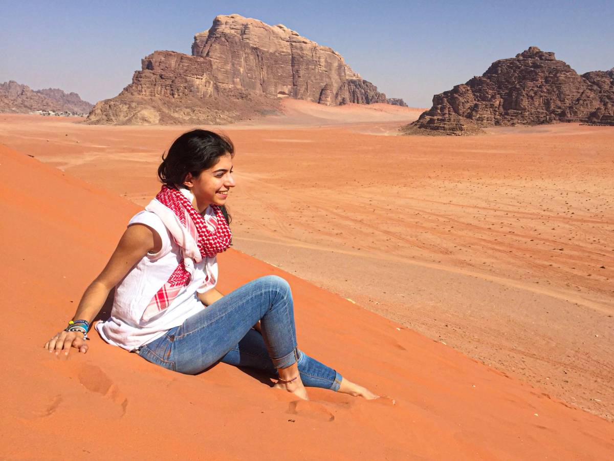 Student sitting in sand dunes in Jordan