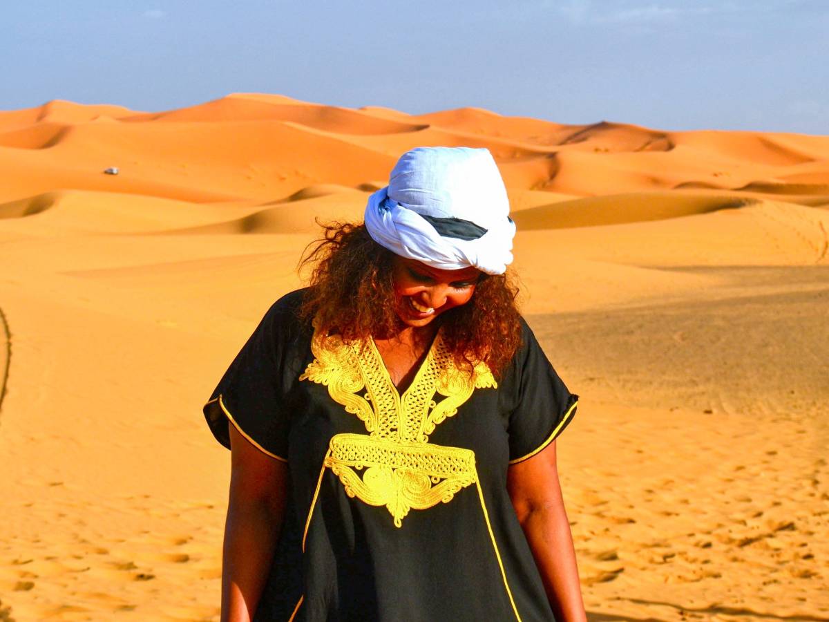 Student smiling on sand dunes in Morocco