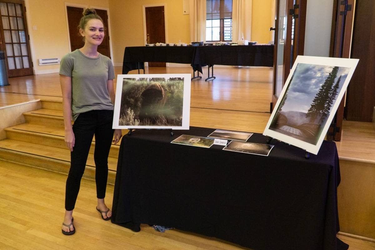 student with photos at final gallery showing