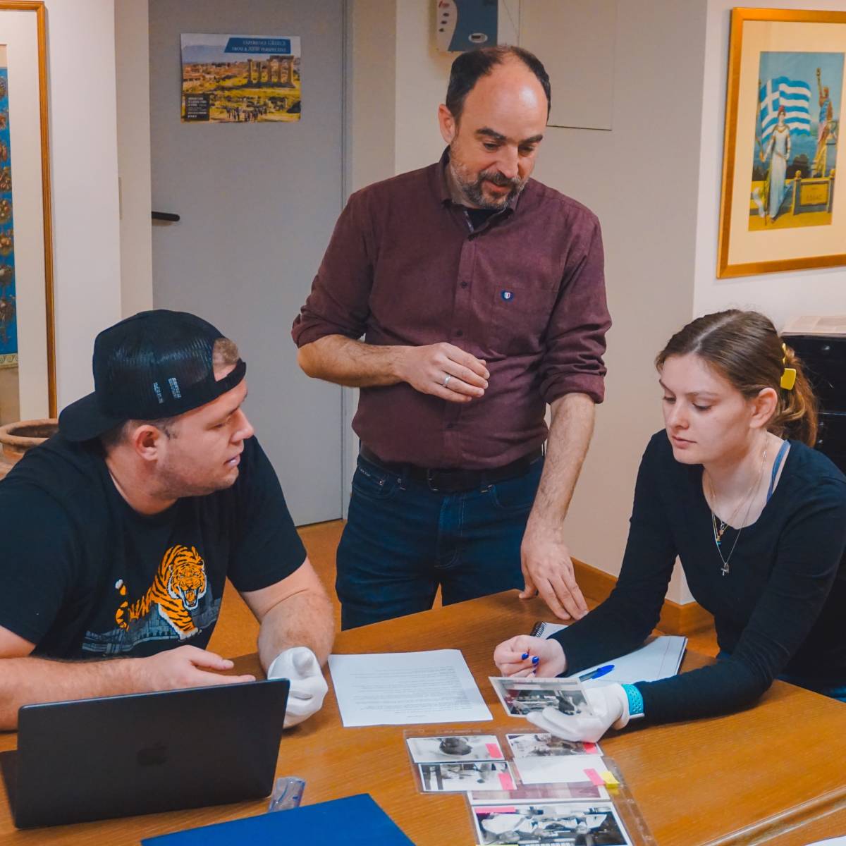 Students and professor looking at archived photos