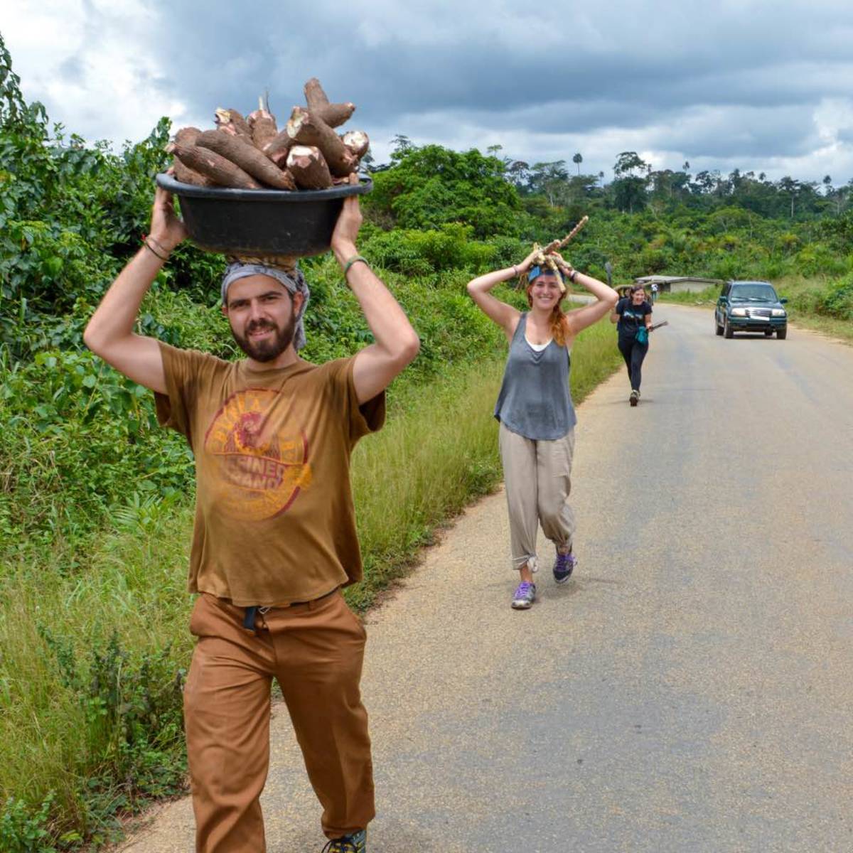 Students carrying supplies on their heads on a road in Ghana.