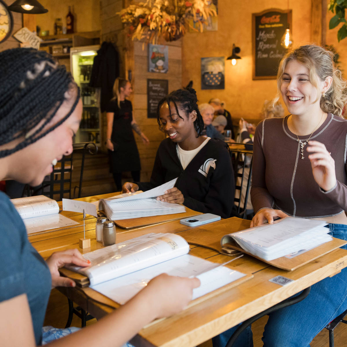 Students chat and study in a cafe. 