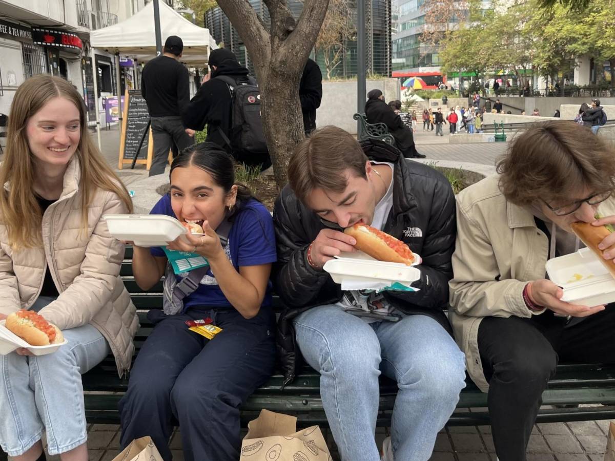 students eating Chilean "completo" hot dogs, with tomato, avocado, and mayo