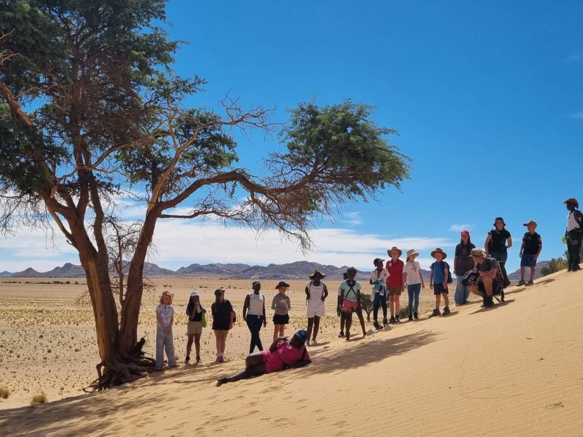 Students gathered under a desert tree in the Namib, Namibia