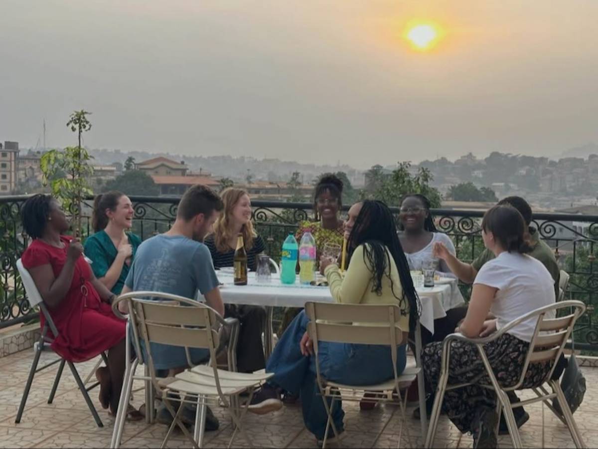 Students laughing around a table at sunset
