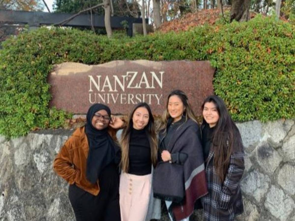 Students pose for a photo in front of the Nanzan University sign in Nagoya.