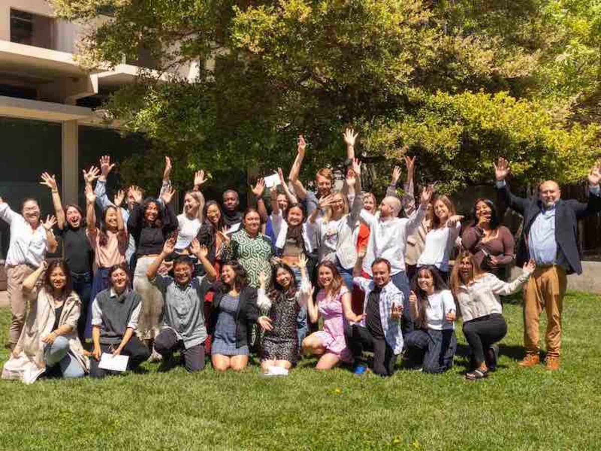 students posing for group pictures, hands up