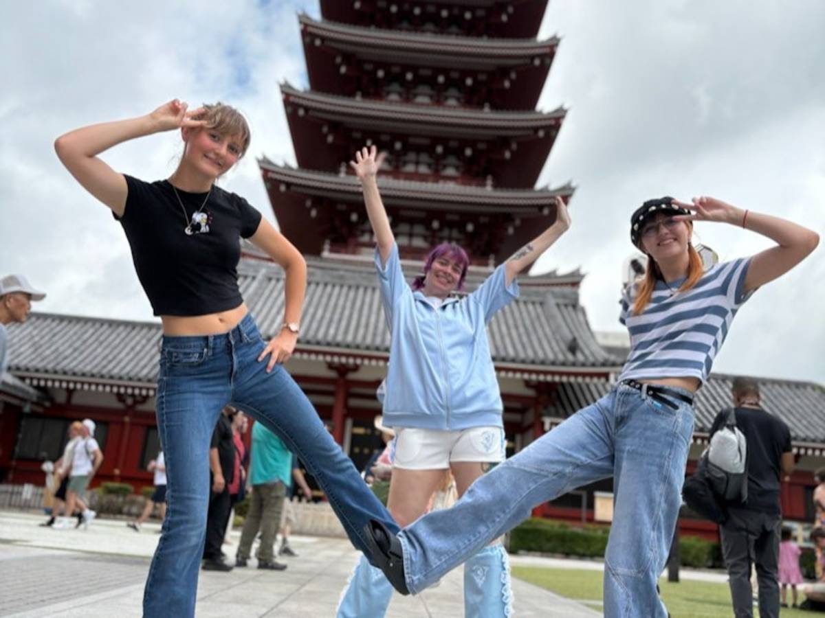 students posing in front of a tall section of the Senso Ji temple