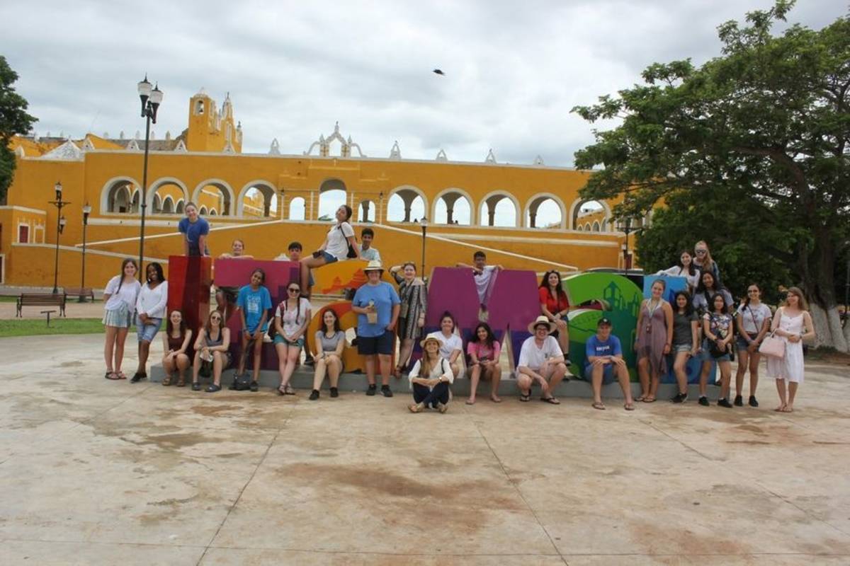 Students posing in front of the Merida sign