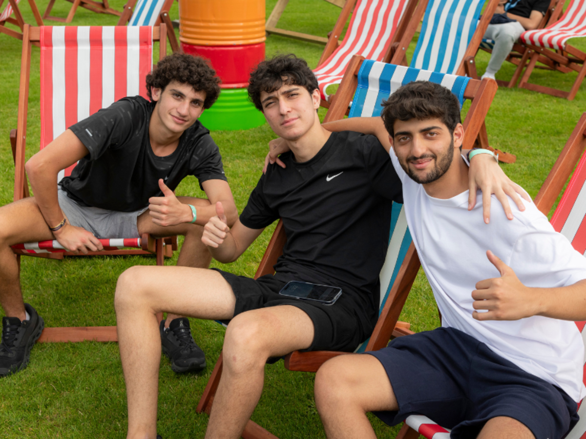 Students smiling in the sunshine on deck chairs
